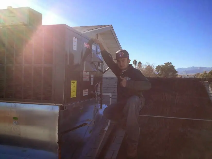 HVAC technician performing Air Duct Cleaning on a rooftop unit in Forest Acres